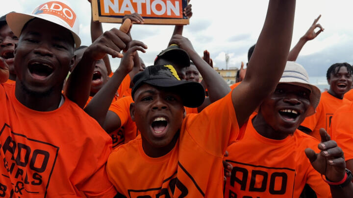 "ADO Girls and Boys" activists get the crowd going at demonstration in support of incumbent President Alassane Ouattara in Abobo, Abidjan on October 21, 2025. 