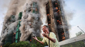 Wong, 71, reacts after saying his wife is trapped inside Wang Fuk Court during a major fire, in Tai Po, Hong Kong, China, November 26, 2025. 