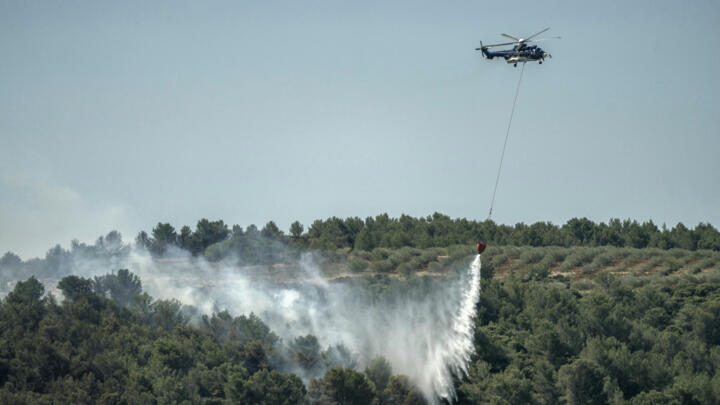 An Airbus H225 helicopter belonging to the French Civil Security Service drops water on a forest fire in Saint-Laurent-de-la-Cabrerisse, in south-western France, on August 6, 2025.