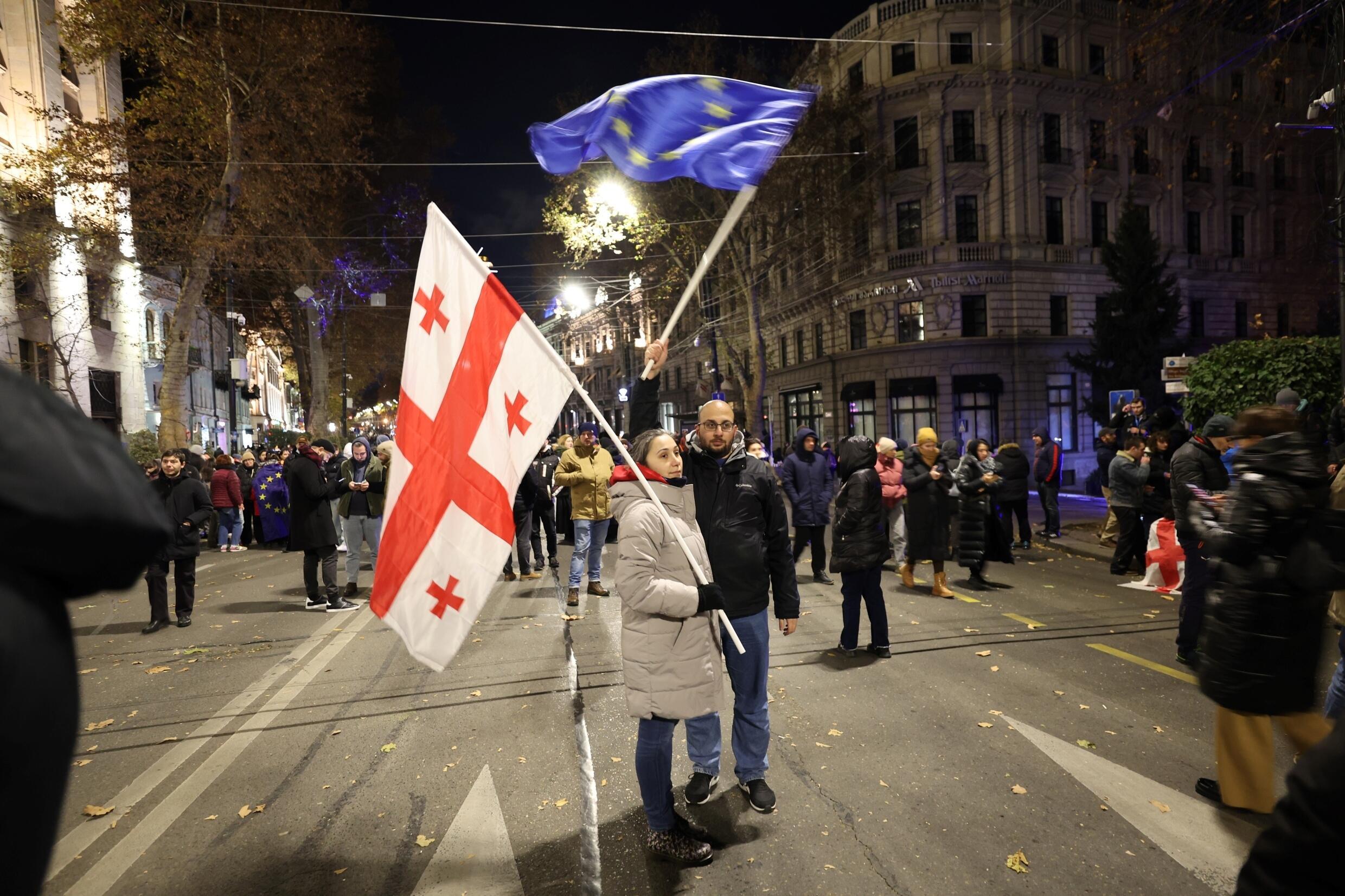 Des manifestants pro-UE brandissent un drapeau géorgien et un drapeau de l'Union européenne lors d'une manifestation devant le Parlement, à Tbilissi, jeudi 12 décembre 2024.