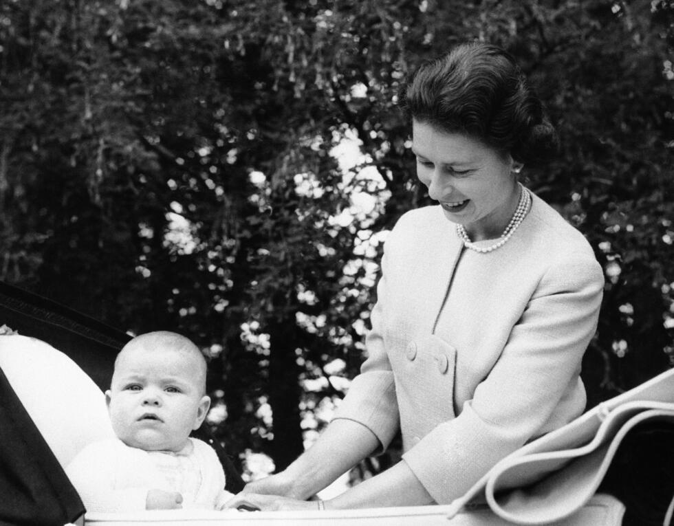 Le prince Andrew, vigilant, est assis dans son landau tandis que sa mère, la reine Elizabeth II, lui sourit, alors que le bébé approchait de son septième mois d'anniversaire, le 13 septembre 1960.