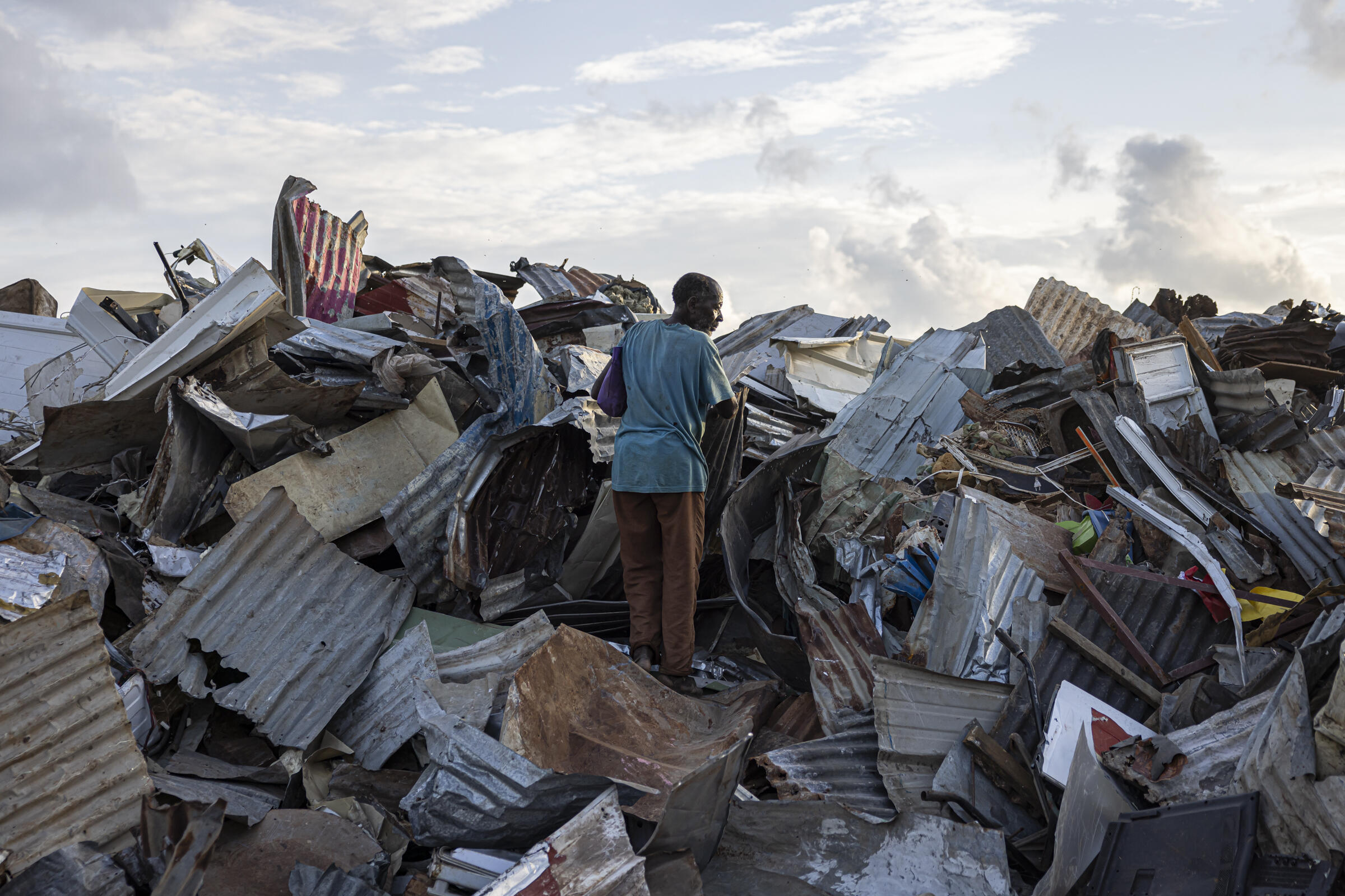 Dans une décharge de Mamoudzou, un homme cherche des tôles pour reconstruire sa maison le 28 décembre 2024.