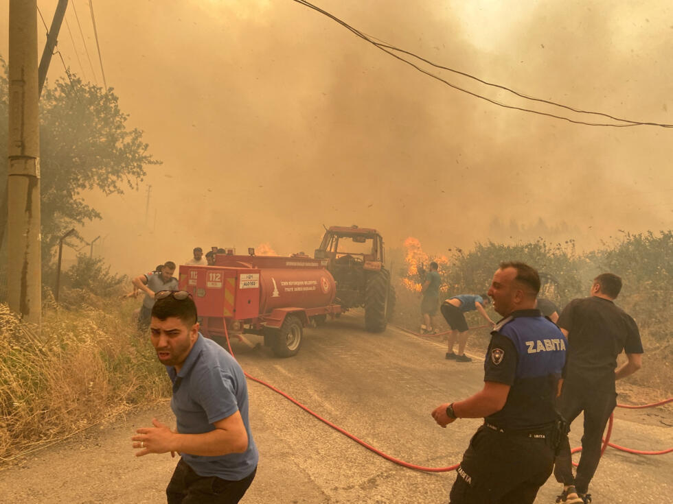 Bomberos y residentes locales responden a un incendio forestal en el distrito de Menderes de la ciudad egea de Izmir, Turquía, 29 de junio de 2025.