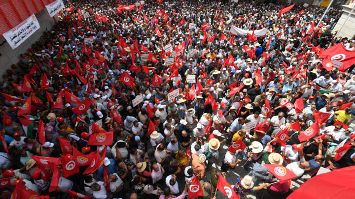 Tunisian supporters of the General Labour Union (UGTT) wave their national flag during a rally in Tunis on August 21, 2025.