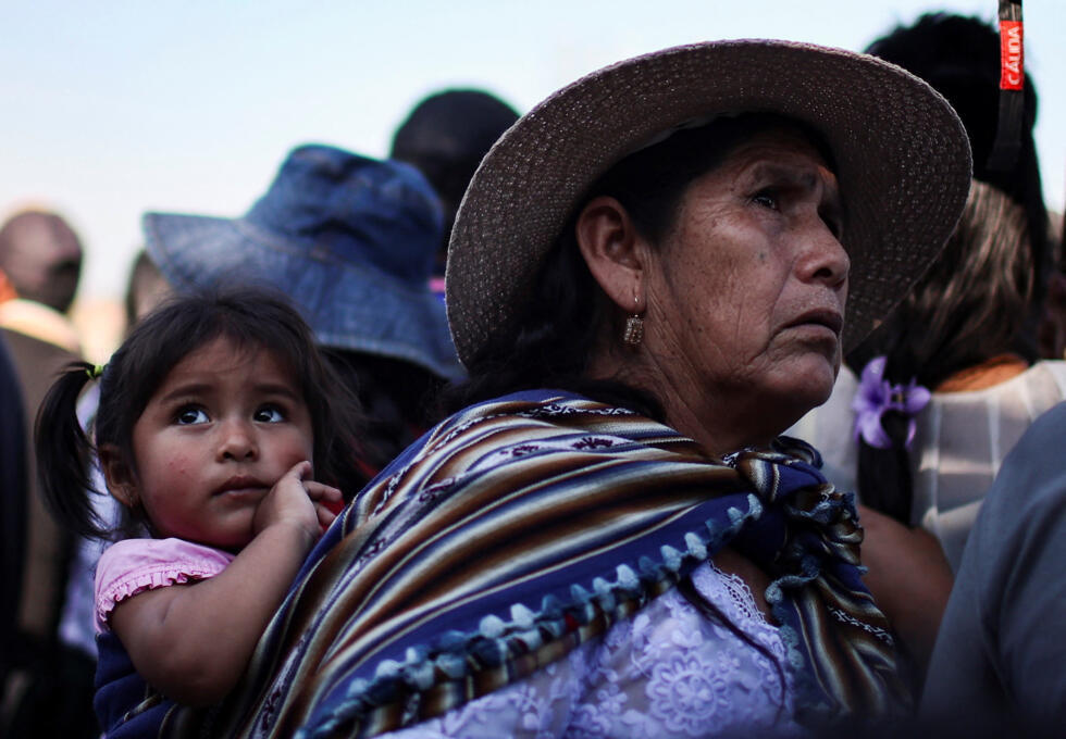 A supporter of Bolivian former president Evo Morales carries a child during a rally to promote "null voting" ahead of the August 17 general election, Entre Rios, Cochabamba, Bolivia, August 14, 2025.