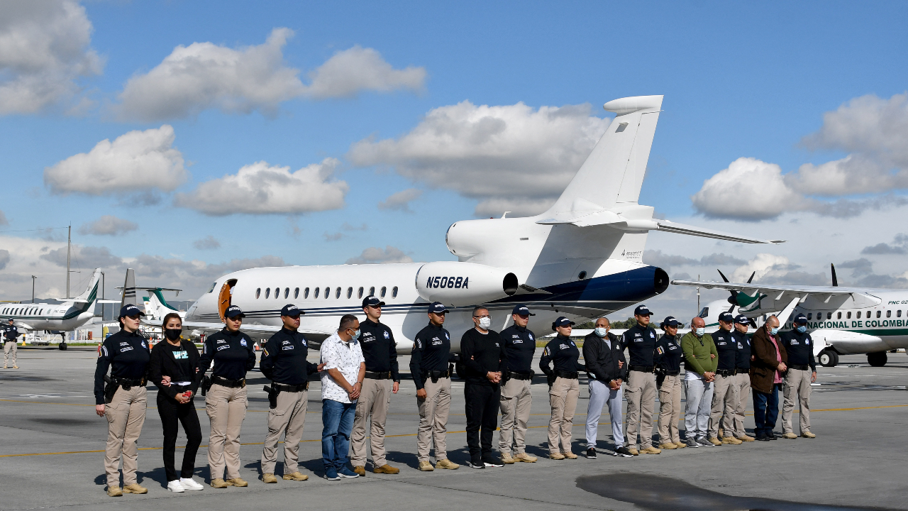Nini Johana Usuga, hermana del narcotraficante Dairo Antonio Usuga, alias 'Otoniel, es escoltada por agentes de la policía de Interpol antes de ser extraditada a Estados Unidos en el aeropuerto internacional El Dorado, en Bogotá, el 1 de julio de 2022.