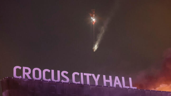 A helicopter helps extinguish a fire at the Crocus City Hall concert venue outside Moscow, Russia, March 22, 2024. 