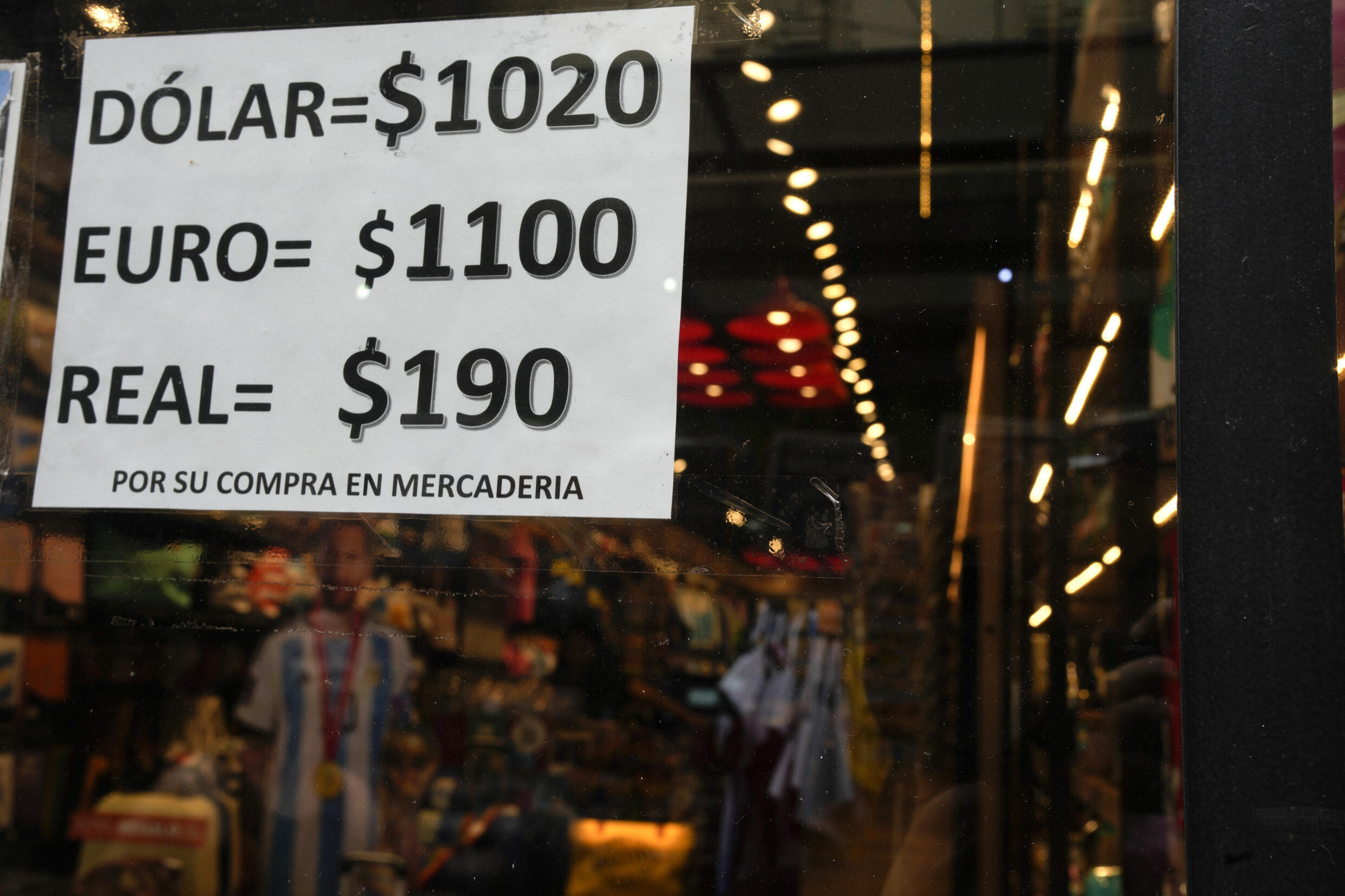 Un letrero muestra el tipo de cambio de dólares, euros y pesos, en el escaparate de una tienda, en Buenos Aires, Argentina, el martes 21 de noviembre de 202