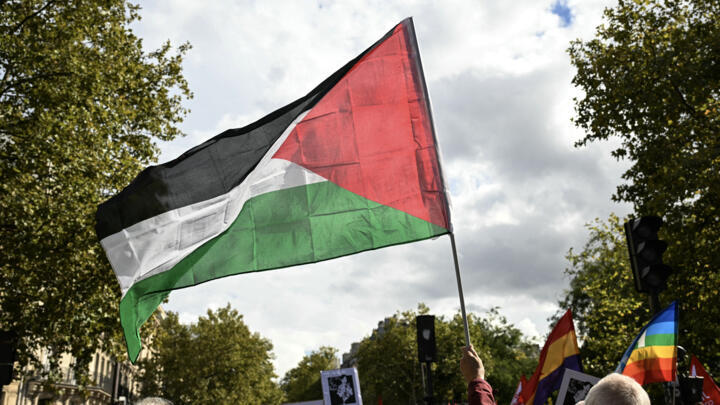 A protester waves a Palestinian flag during a march asking for the "recognition of the State of Palestine and the end of the genocide", in Paris on September 21, 2025.