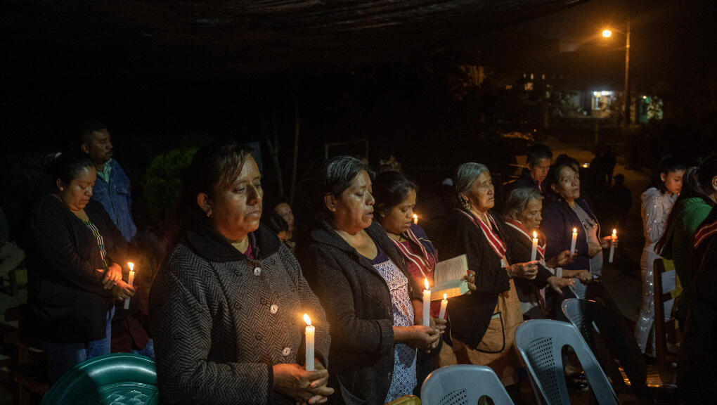 Los residentes de San Marcos Atexquilapan, en el estado de Veracruz, México, en una vigilia a la luz de las velas para orar porque tres adolescentes locales, dos hermanos y un primo, no se encuentran entre los 53 migrantes que murieron en un camión en Texas. Jueves 30 de junio de 2022.