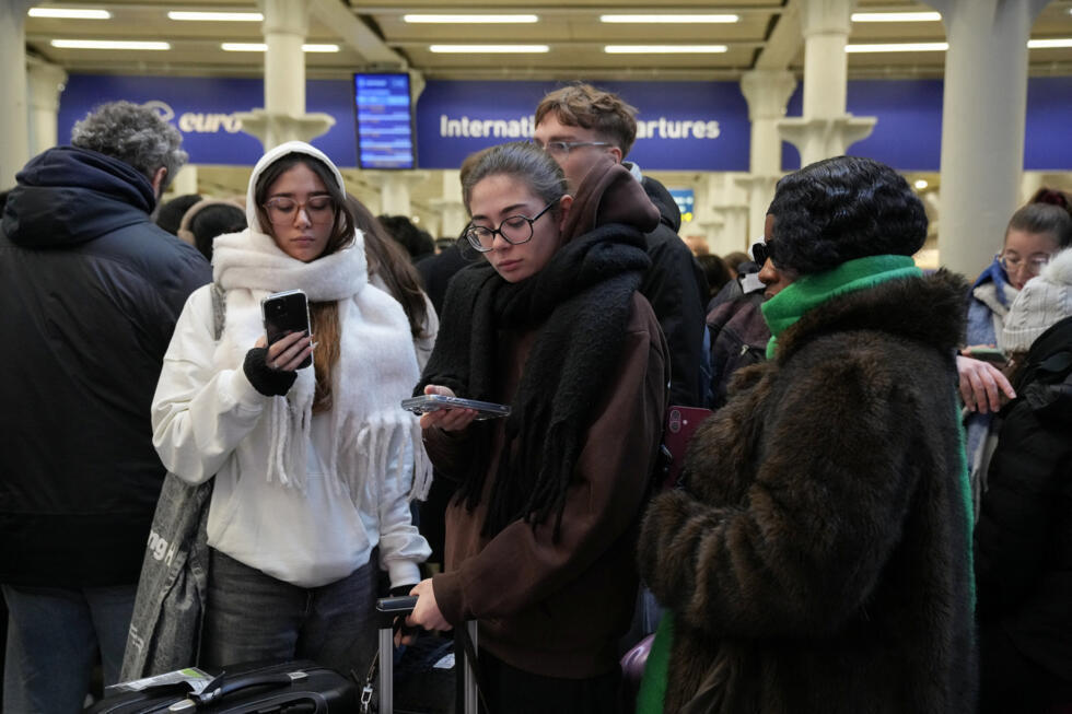 Los pasajeros utilizan sus teléfonos móviles, después de que un portavoz de Eurostar anunciara la suspensión de los servicios ferroviarios que cruzan el Canal de la Mancha desde y hacia Londres hasta nuevo aviso, debido a un problema en el suministro eléctrico del túnel del Canal de la Mancha que une Gran Bretaña y Francia, en la estación St. Pancras International de Londres, Gran Bretaña, el 30 de diciembre de 2025.