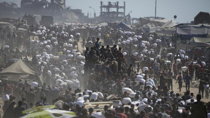 Palestinians carry sacks of flour taken from a humanitarian aid convoy in the outskirts of Beit Lahiya, northern Gaza Strip, August 1, 2025.