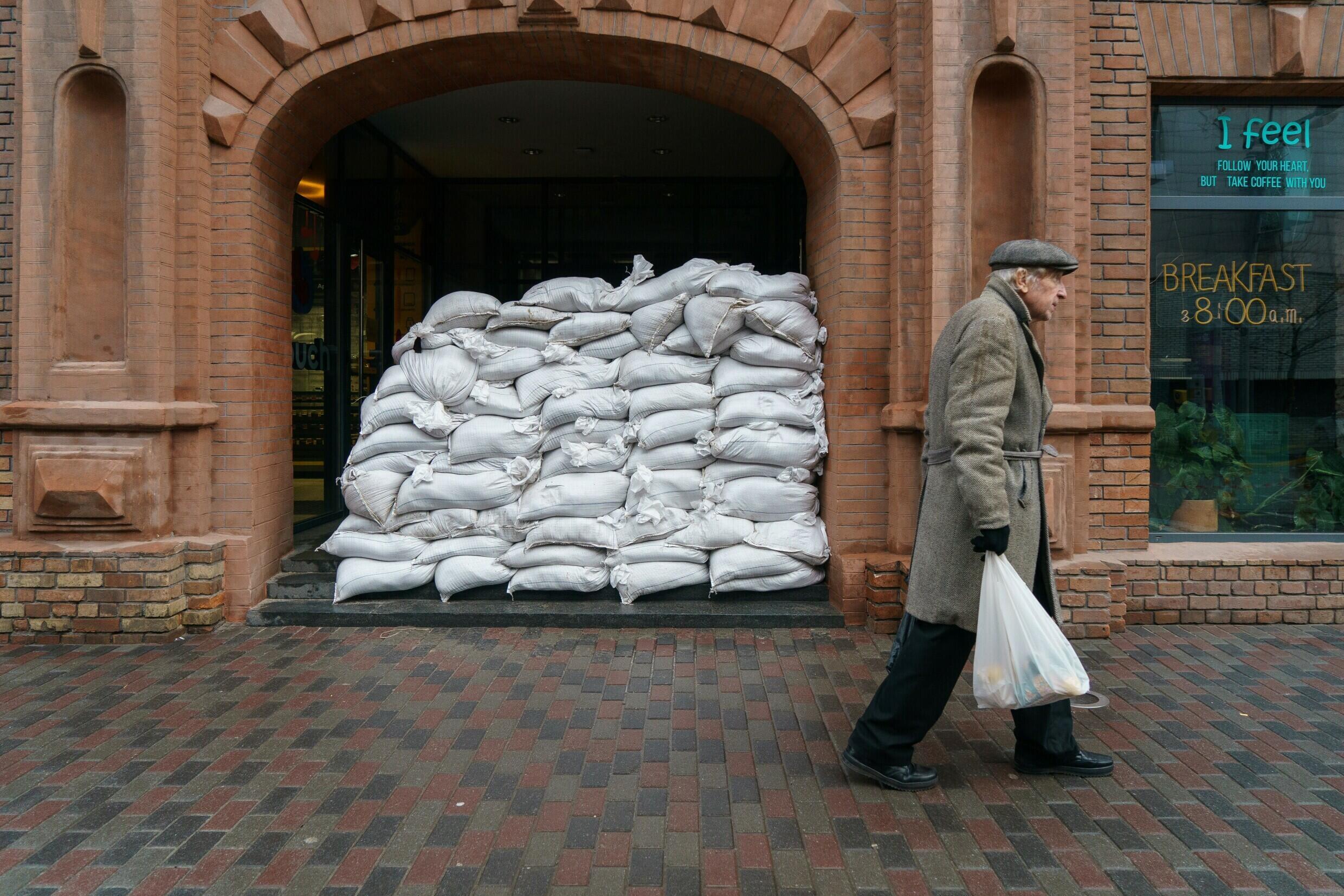 A man walks past sandbags protecting the entrance of a cafe in the Ukrainian city of Dnipro