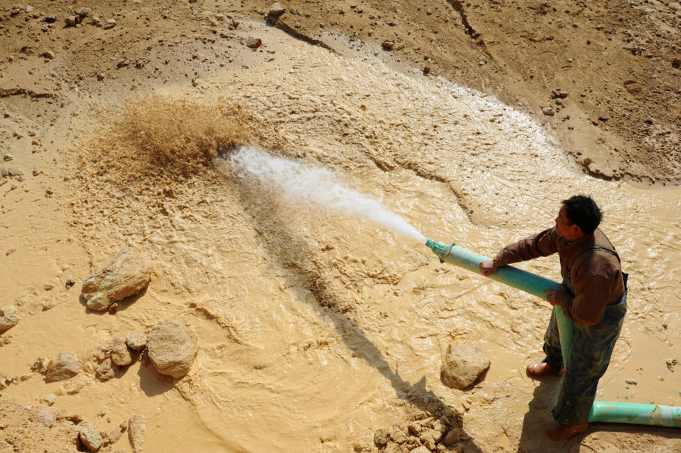 Foto de archivo de un trabajador arrojando agua a presión en un yacimiento de metales de tierras raras en el condado de Nancheng, provincia de Jiangxi, el 16 de enero de 2011.
