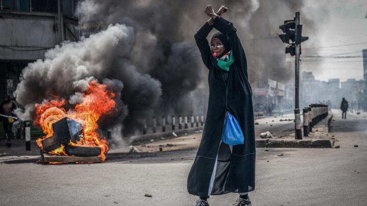 A protester reacts in front of a burning barricade in downtown Nairobi on June 25, 2025 during a planned day of protest marking the first anniversary of the storming of the parliament.