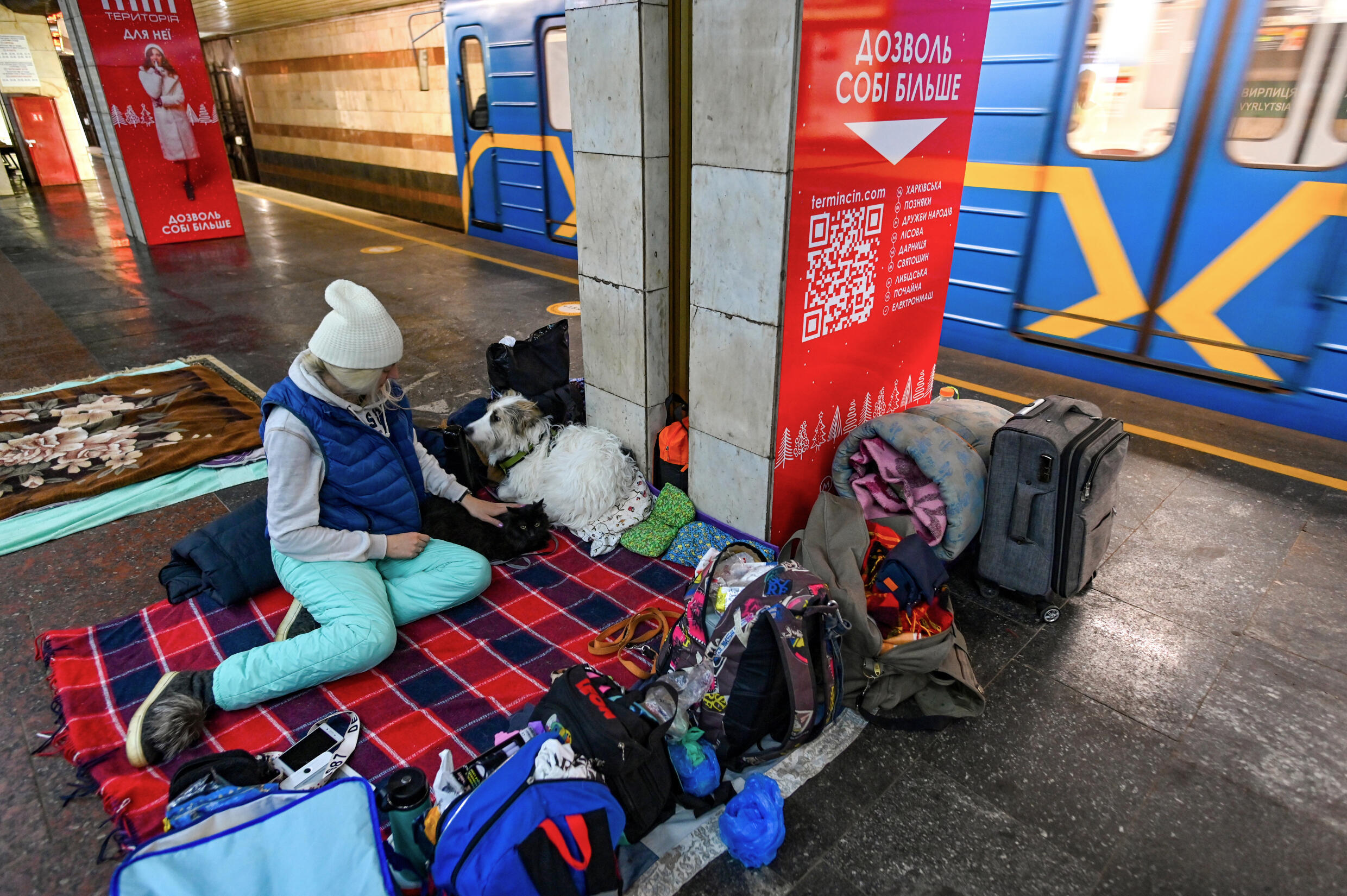 A woman takes shelter in an underground metro station in Kyiv