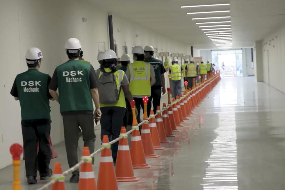 Esta imagen, proveniente de un video proporcionado por el Servicio de Inmigración y Control de Aduanas de EE. UU. (ICE) a través de DVIDS, muestra a empleados de una planta de fabricación siendo escoltados fuera de la planta de vehículos eléctricos de Hyundai Motor Group, el jueves 4 de septiembre de 2025, en Ellabell, Georgia.