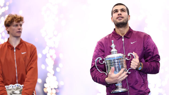 Spain's Carlos Alcaraz kisses his trophy after winning the men's singles final tennis match against Italy's Jannik Sinner (L) on day fifteen of the US Open tennis tournament at the USTA Billie Jean King National Tennis Center in New York City on September 7, 2025.