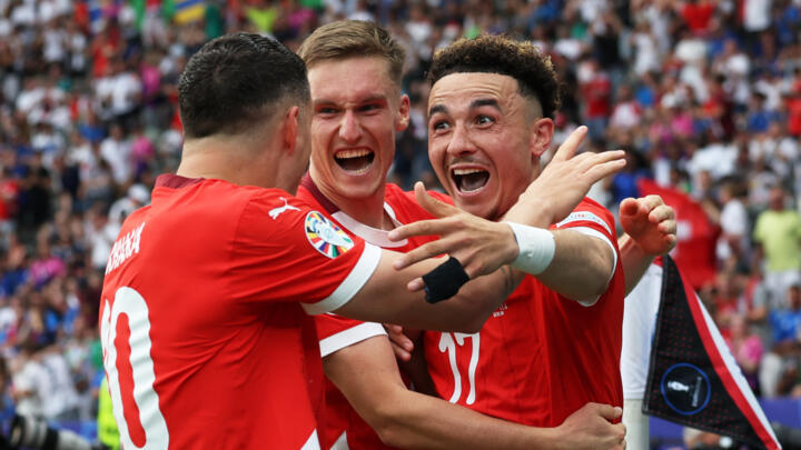 Switzerland's midfielder  Ruben Vargas (R) celebrates with teammates after scoring his team's second goal against Italy.