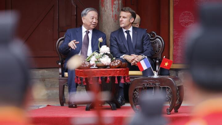 France's President Emmanuel Macron (R) and Vietnam's General Secretary of the Communist Party To Lam (L) attend a ceremony at the Temple of Literature in Hanoi on May 26, 2025.