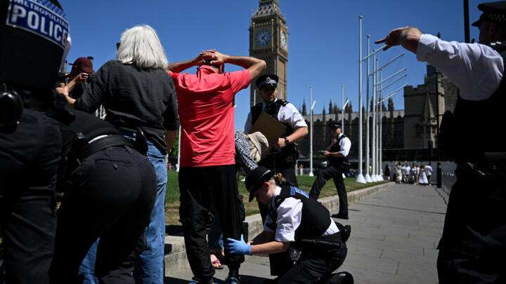 A Protester is searched before being arrested as people gather in support of the pro-palestinian group "Palestine Action", in Parliament Square, London on July 12, 2025.