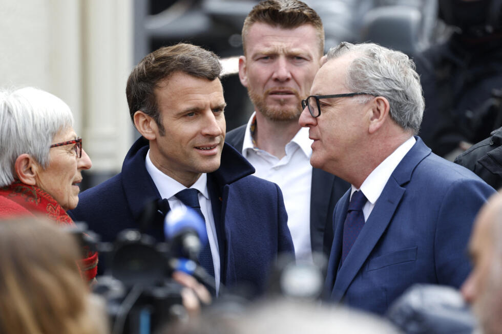 French President Emmanuel Macron speaks with Former-President of the French National Assembly Richard Ferrand as he arrives for a campaign visit in Spezet, western France, on April 5, 2022.