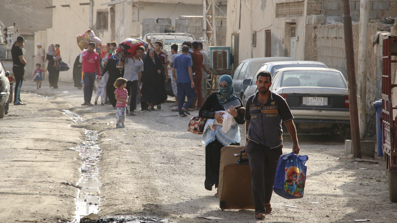 Personas sunitas que huyen de la violencia caminan por una carretera en la ciudad de Ramadi, Irak, 15 de mayo 2015