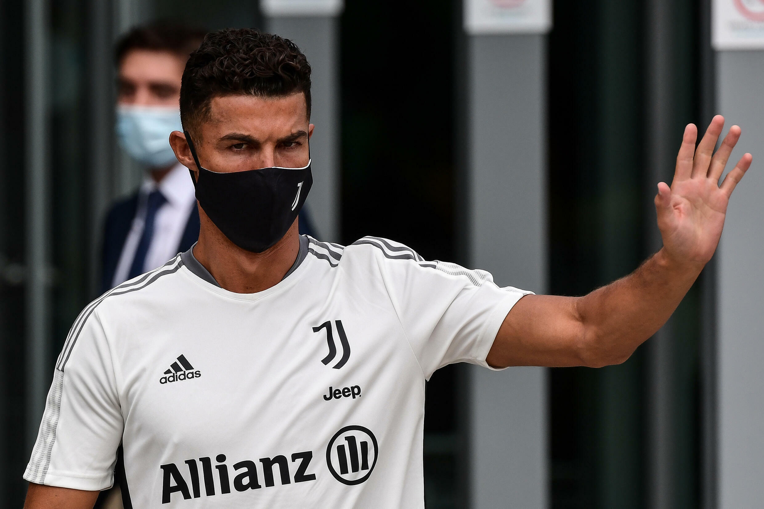La estrella de la Juventus, Cristiano Ronaldo, saluda a los fanáticos después de su visita médica al centro médico del club el 26 de julio de 2021 en Turín.