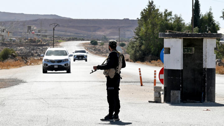 A member of Syria's security forces stands guard at a checkpoint near the city of Quneitra