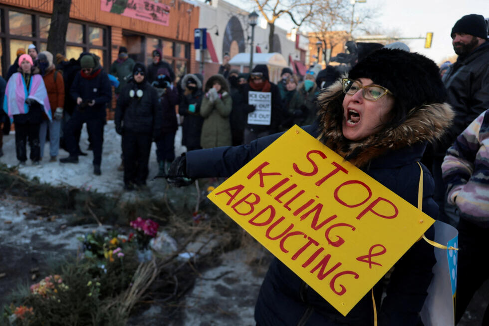 La gente se reúne alrededor de un memorial improvisado en el lugar donde un hombre fue asesinado a tiros por agentes federales que intentaban detenerlo, en Minneapolis, Minnesota, EE. UU., el 24 de enero de 2026.