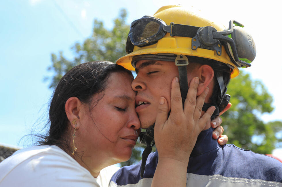 Rescued miner Dani Sebastian Agudelo embraces a relative near the site where a gold mine collapsed, trapping 23 miners in Segovia in Colombia on September 24, 2025.