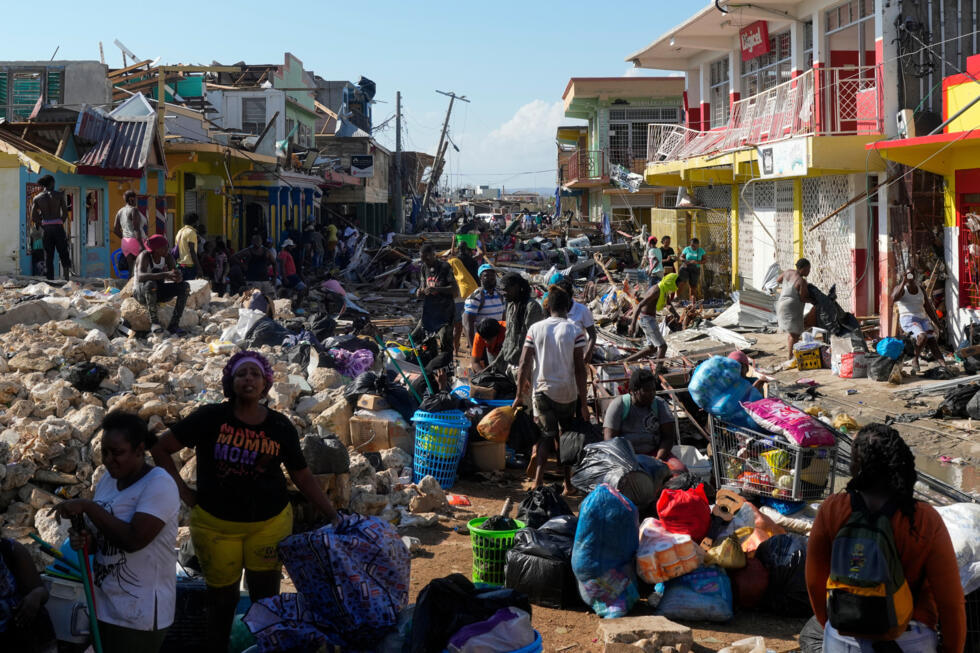 Residents gather amid debris on a street in Black River, Jamaica, on October 30, 2025, after Hurricane Melissa left a trail of destruction and death in the Caribbean.