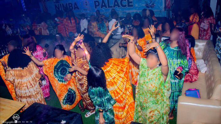 Women dressed in boubous dance at a "Dior party" in the Nimba Palace nightclub in Conakry, Guinea, on August 1, 2025.