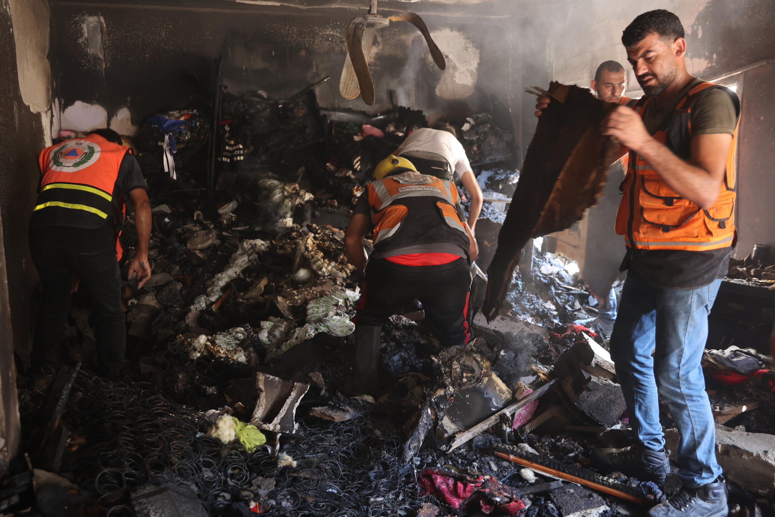 Des Palestiniens et des secouristes fouillent les décombres d'un appartement détruit dans un bombardement israélien du quartier d'al-Daraj dans la ville de Gaza, le 3 juillet 2024