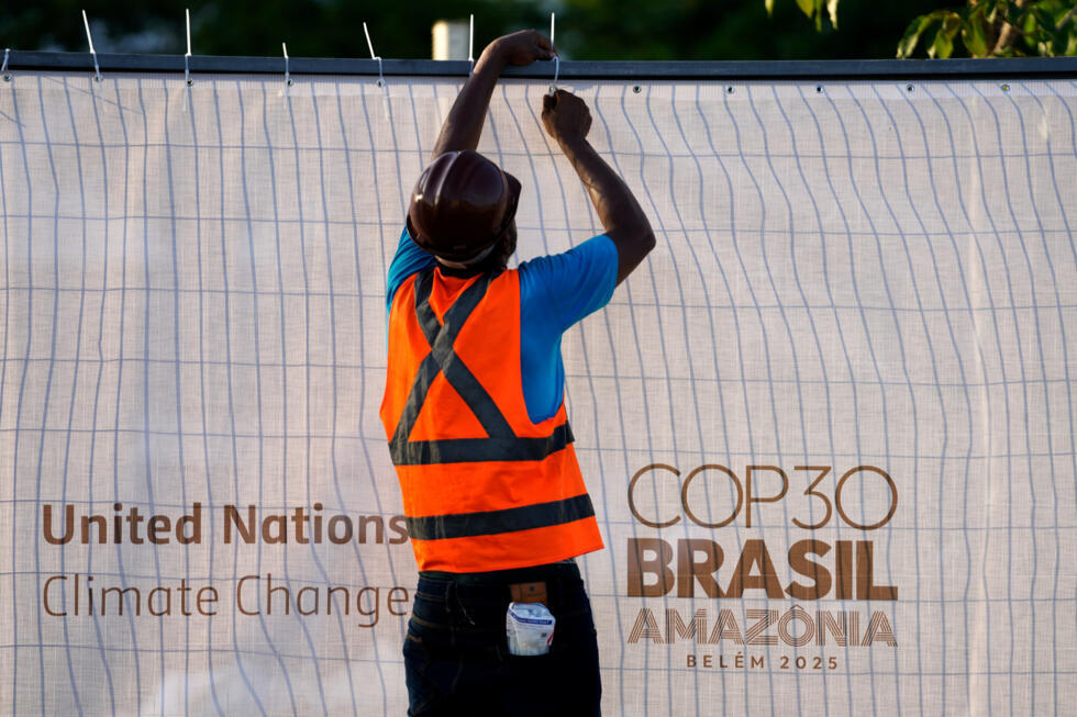 Un trabajador coloca un cartel de la COP30, la Cumbre del Clima de las Naciones Unidas, fuera del centro de prensa en Belém, estado de Pará, Brasil, el martes 4 de noviembre de 2025.