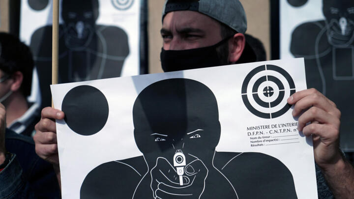 French police hold paper shooting targets following an attack on the police station in Champigny-sur-Marne, east of Paris, on October 12, 2020.