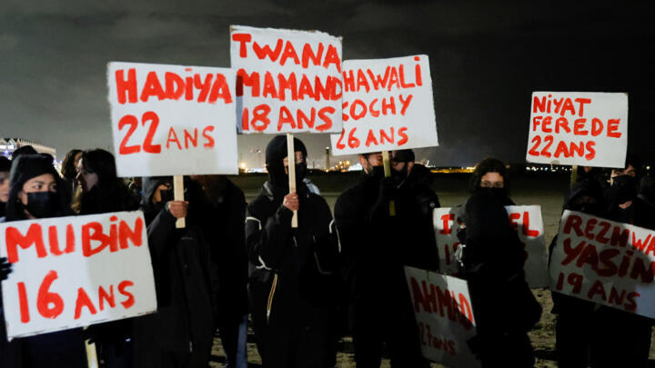 People hold placards in the French city of Dunkirk bearing the names of migrants who died in a shipwreck while trying to cross the English Channel last year.