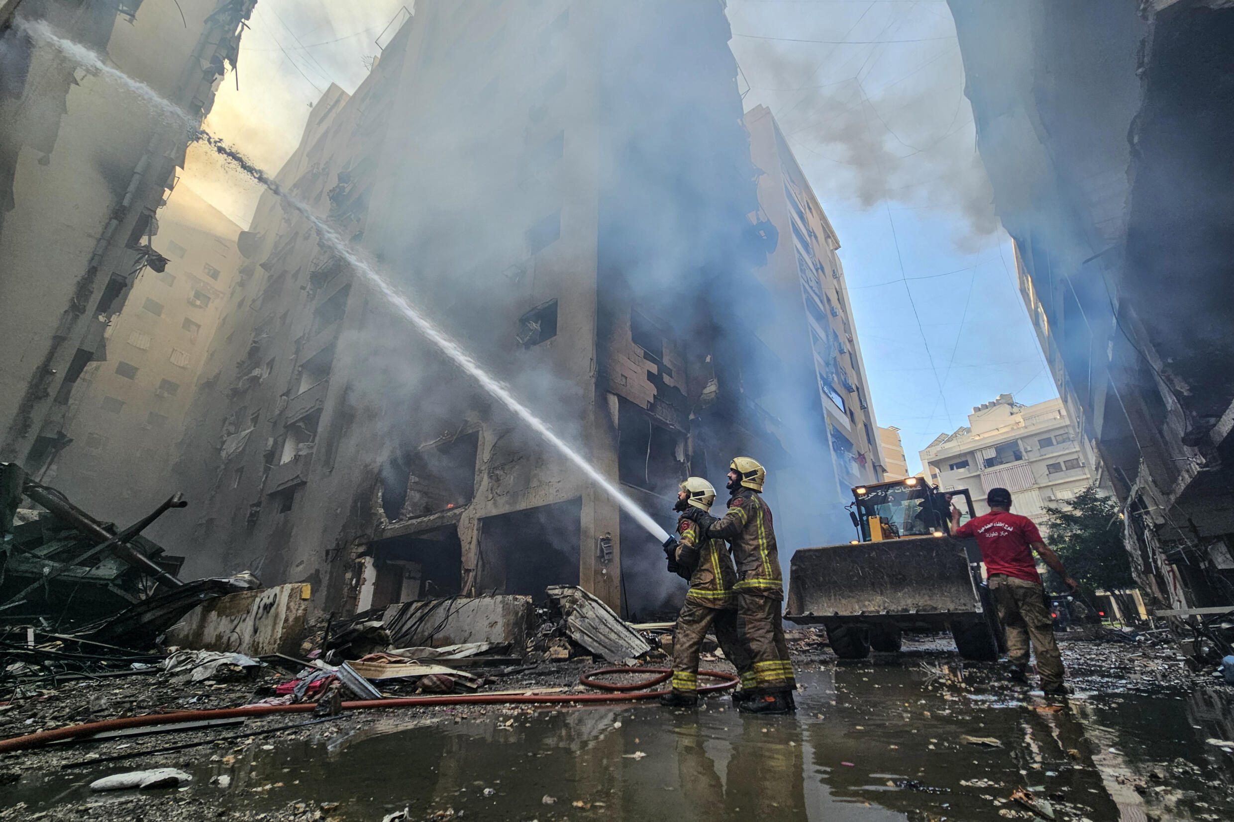 Des pompiers libanais tentent d'éteindre l'incendie d'un bâtiment touché par une frappe israélienne dans la banlieue sud de Beyrouth, le 21 novembre 2024.