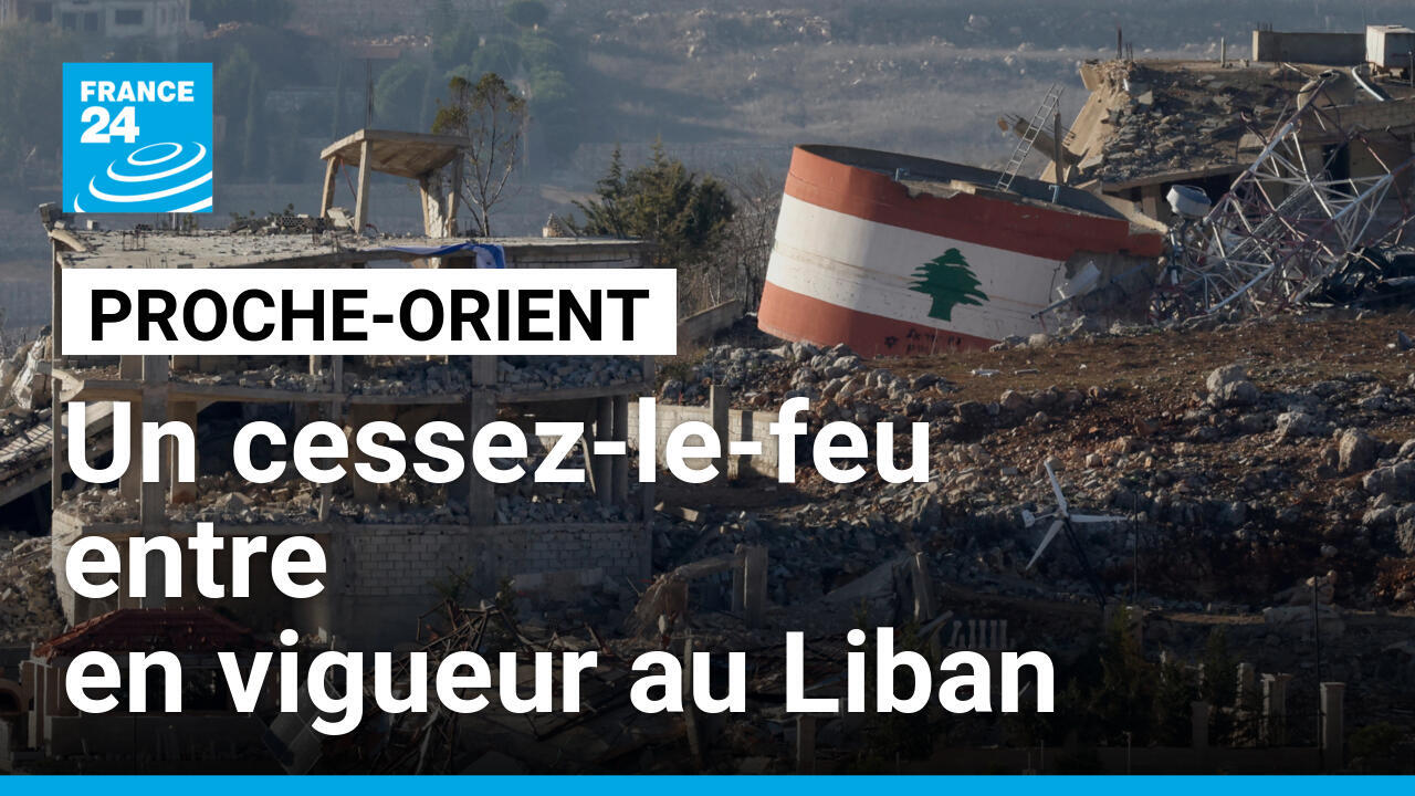 Un drapeau israélien (gauche) est accroché à un bâtiment détruit, à côté d'un drapeau libanais (droite) peint sur un bâtiment endommagé, le 25 novembre 2024 à la frontière entre Israël et le Liban.