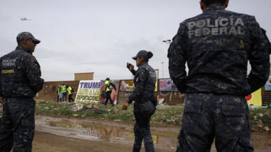 Mexican police watch a protest against US president Donald Trump's migration policies in Tijuana