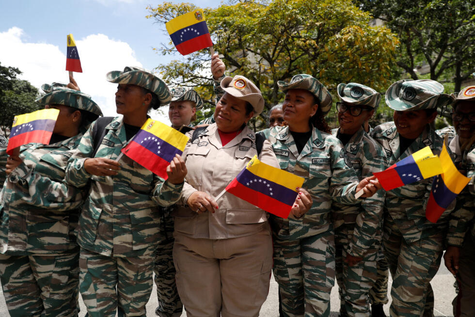 Miembros de la Milicia Nacional Bolivariana sostienen banderas durante la llegada del ministro de Defensa de Venezuela, Vladimir Padrino López (no aparece en la foto), tras el llamamiento del presidente venezolano Nicolás Maduro a una campaña de reclutamiento a nivel nacional, en medio de las crecientes tensiones con Estados Unidos por el despliegue de buques de guerra estadounidenses en el sur del Caribe y aguas cercanas, que según funcionarios estadounidenses tiene como objetivo hacer frente a las amenazas de los cárteles de la droga latinoamericanos, en Caracas, Venezuela, 29 de agosto de 2025.