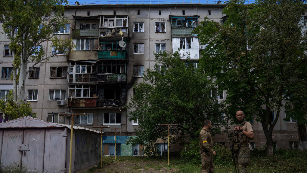 Soldados ucranianos frente a un edificio residencial de cinco pisos dañado por un ataque con cohetes en una zona residencial, en Kramatorsk, este de Ucrania, martes 19 de julio de 2022.