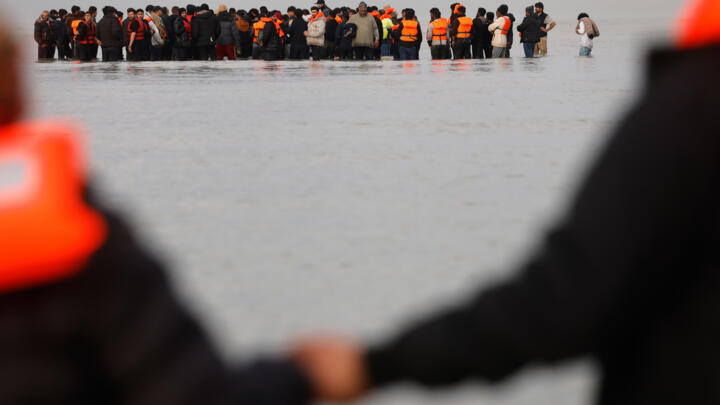 مهاجرون يدفعون قاربا صغيرا في محاولة للوصول إلى بريطانيا، الخميس 6 نوفمبر/تشرين الثاني 2025، في غرافلين، شمال فرنسا.