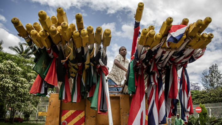 Nairobi City County workers unload a truck with flags of Kenya and the United Kingdom as they install them in the streets ahead of King Charles III's visit to Kenya on October 30, 2023.