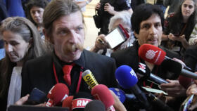 Eagles of Death Metal singer Jesse Hughes, left, and guitarist Eden Galindo, right, answer reporters outside the special court room on May 17 2022 in Paris.