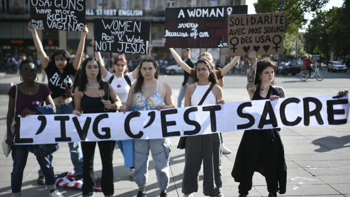 Protesters hold a banner reading "Abortion is sacred" during a rally in support of worldwide abortion rights in Paris, after the US Supreme Court's overturned America's constitutional right to abortion, on June 24, 2022.