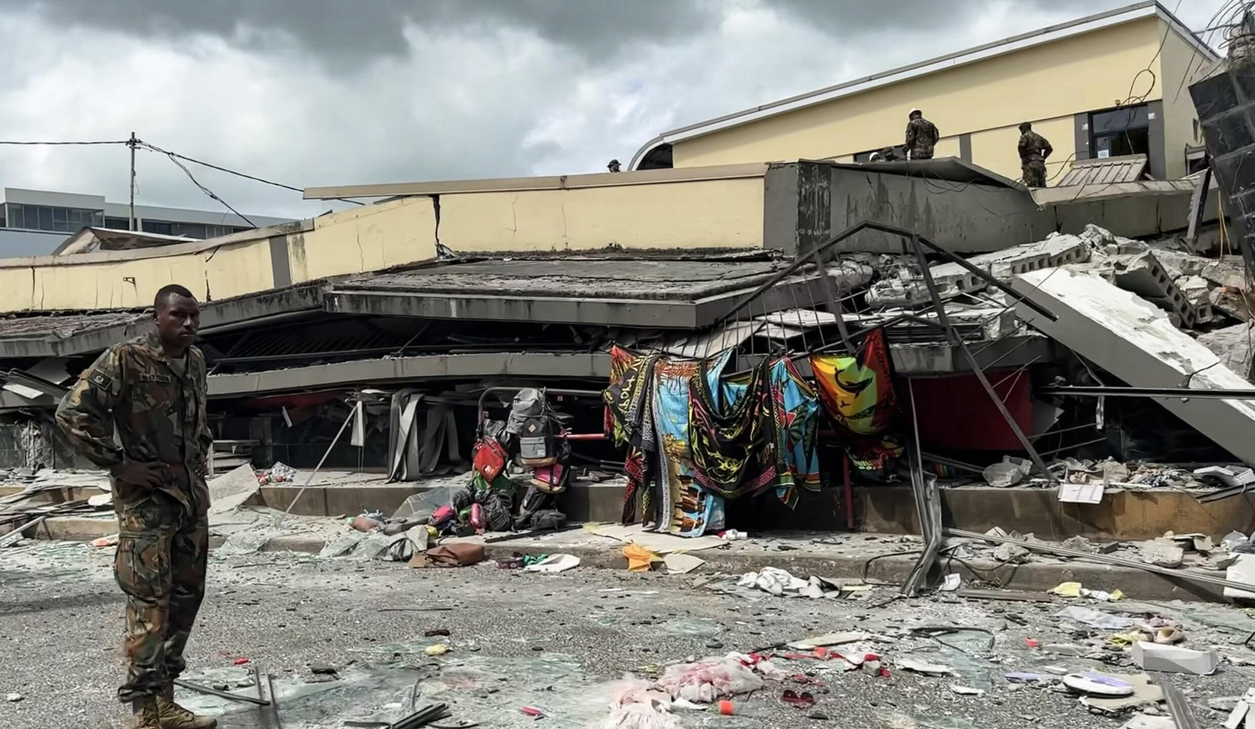 Un membre des services de sécurité inspecte les décombres d'un bâtiment détruit par un puissant séisme, à Port-Vila (Vanuatu), mardi 17 décembre 2024.