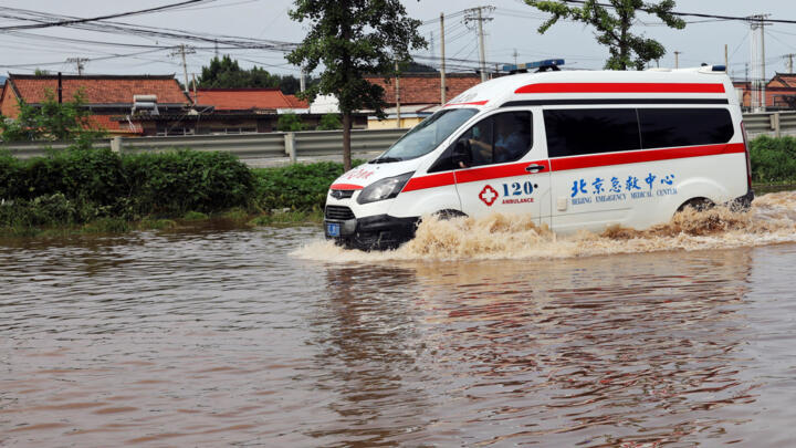 An ambulance drives through floodwaters after a heavy rainfall flooded the area in Miyun district of Beijing, China July 28, 2025.