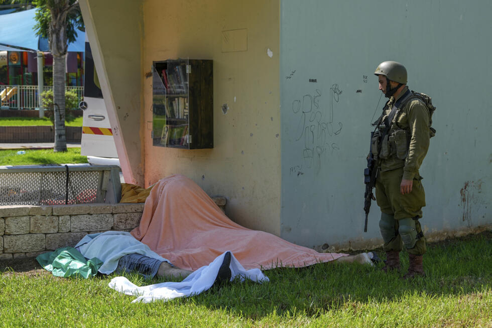 Un soldado israelí junto a los cuerpos de ciudadanos israelíes asesinados por militantes armados palestinos que ingresaron desde la Franja de Gaza, en la ciudad de Sderot, en el sur de Israel, el sábado 7 de octubre de 2023.