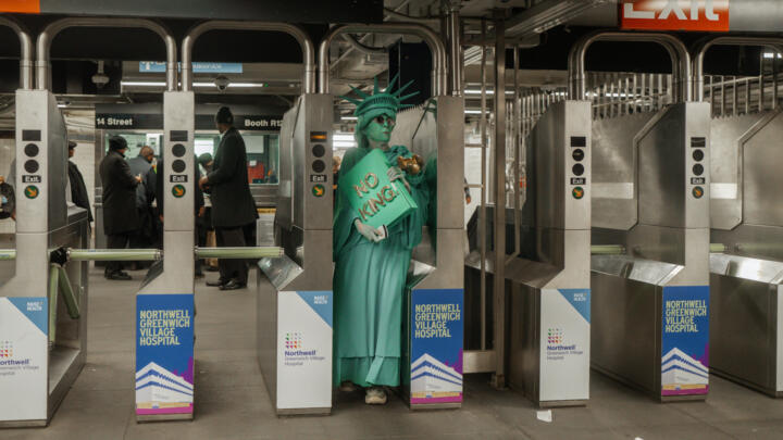 A protester dressed in a Statue of Liberty costume enters a New York subway station after a "No Kings" protest October 18, 2025.